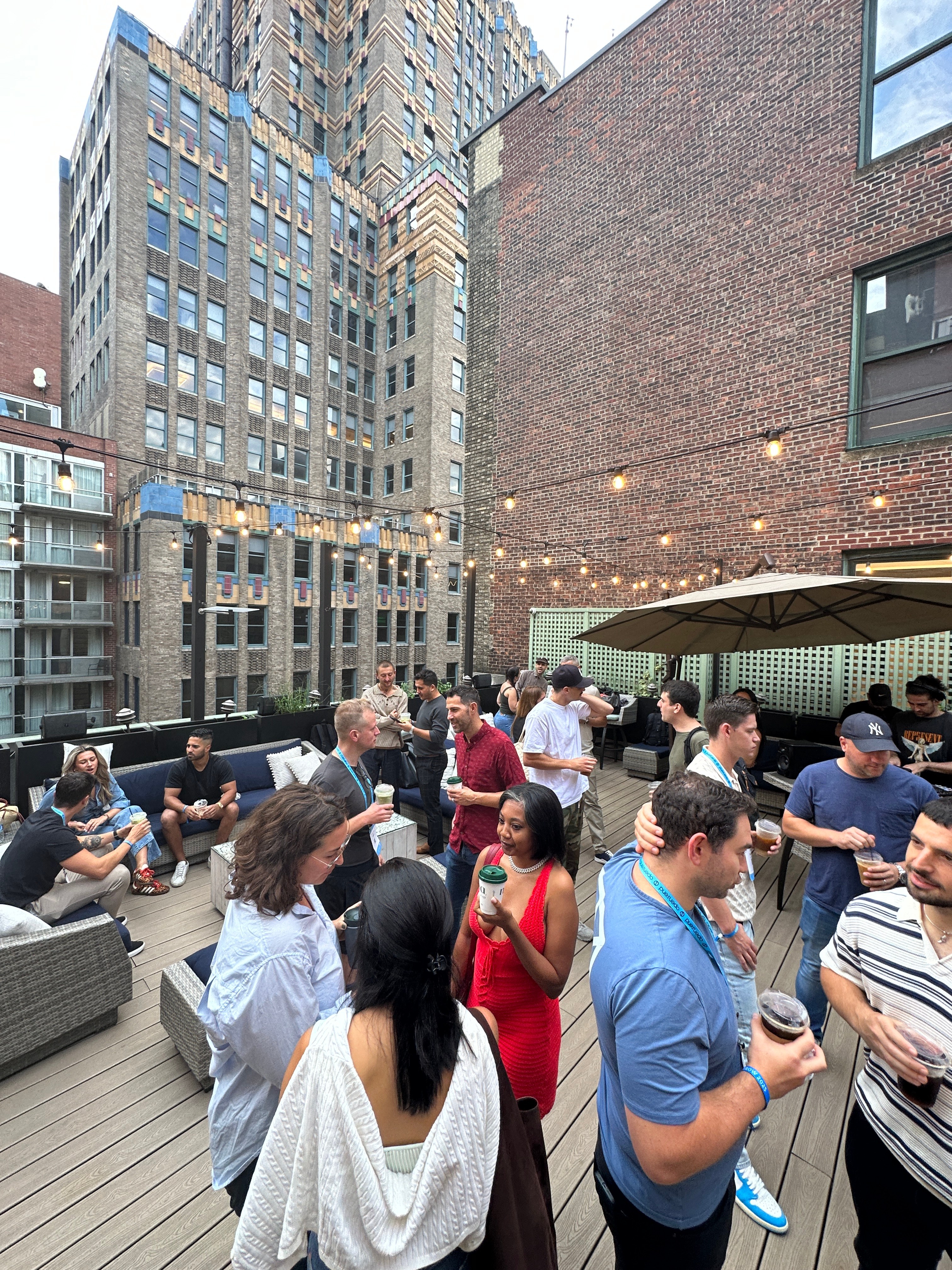 Rooftop networking event with string lights and skyline views