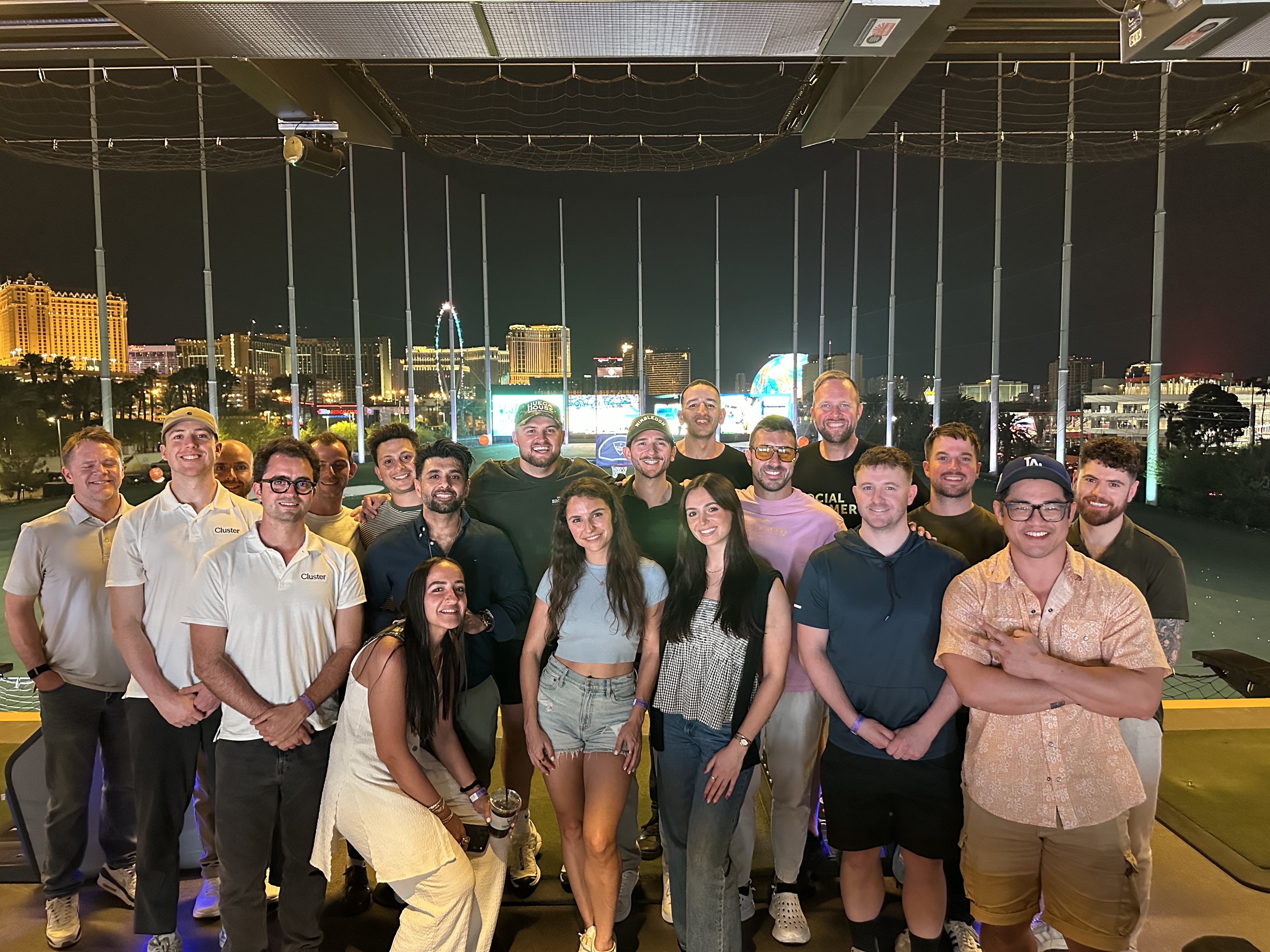 Group photo at Topgolf with the Las Vegas Strip lit up behind